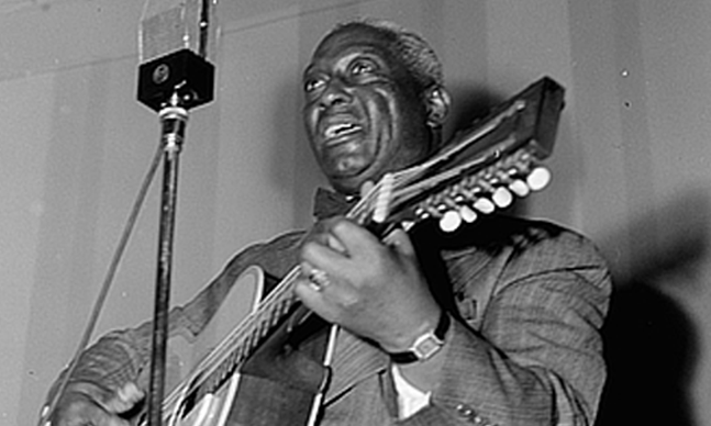 Leadbelly playing guitar.